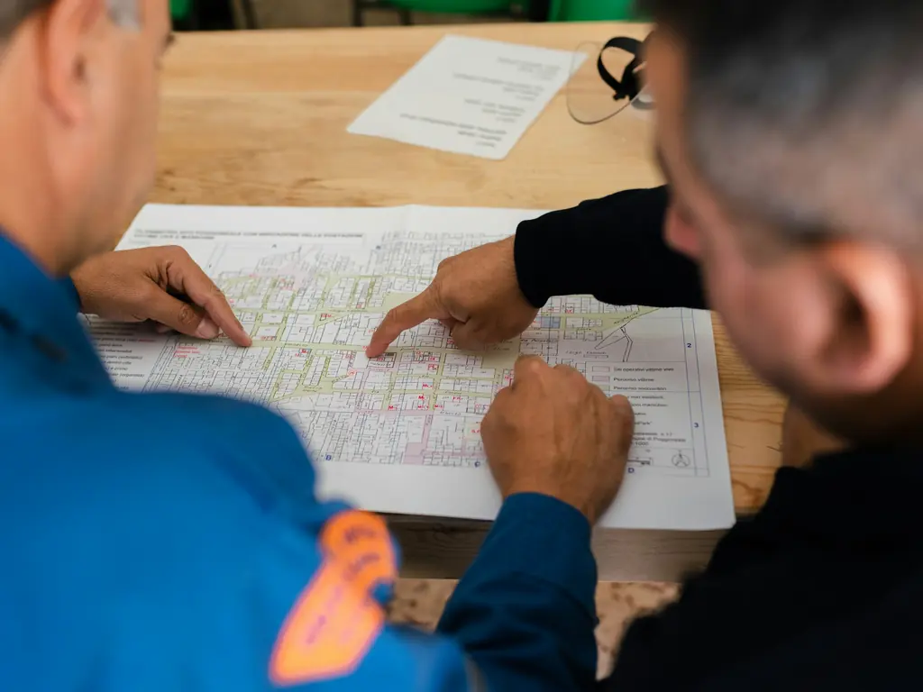 Dos personas revisando un plano de instalaciones sobre una mesa